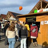 Besucherinnen und Besucher stehen am Waffelstand der ‚Waffelbäckerbande‘ des Fördervereins der Grundschule Ranis e. V. beim Kürbisfest 2025.
