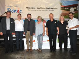Team Marktzentrum Ranis bei öffentlicher Vorstellung des Projekts vor dem Banner ‚Mittendrin – das kleine Stadtzentrum.“