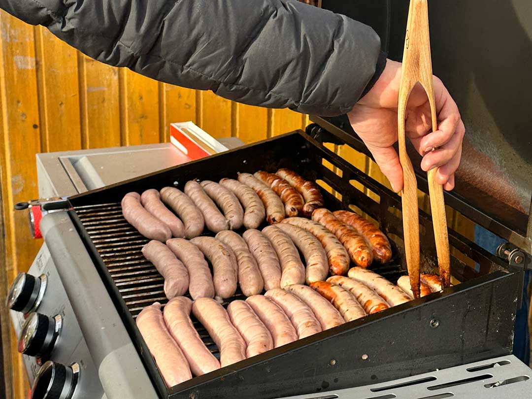 Frisch gegrillte Rostbratwürste auf dem Grill beim Marktzentrum Ranis, regionale Spezialität bei Veranstaltungen der Genossenschaft.