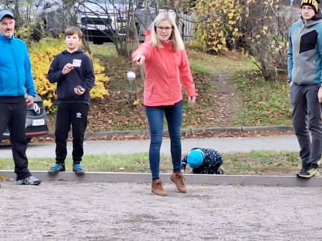 Teilnehmerin wirft eine Boulekugel beim 1. Bouleturnier in Ranis, während Zuschauer und Mitspieler das Spiel verfolgen.