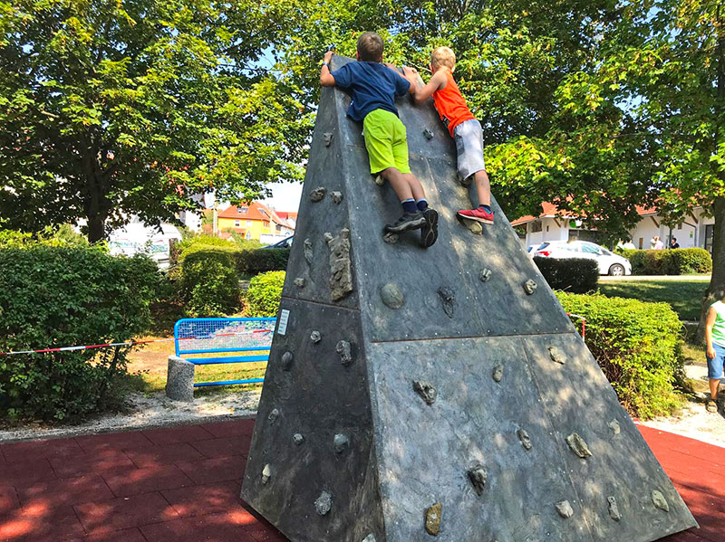 Kinder klettern auf der Kletterpyramide am Marktzentrum Ranis bei sonnigem Wetter – Freizeitangebot für Familien und Besucher.